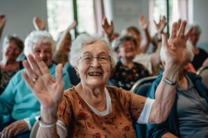 Older adults participating in a group chair exercise class indoors, with natural light and cheerful expressions.